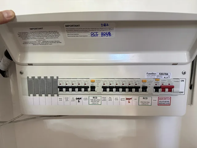 Open consumer unit lid showing circuit labels and protective devices