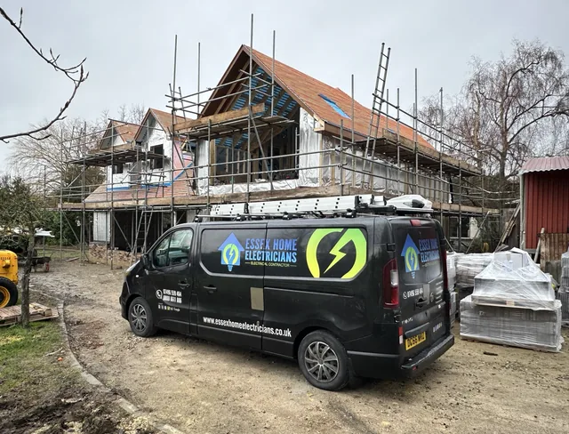 Essex Home Electricians van outside a house renovation with scaffolding