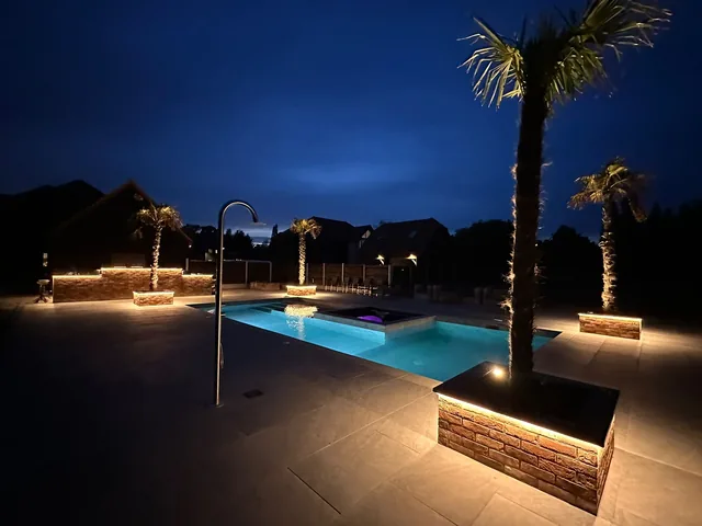 Illuminated garden planters and pool area after dark