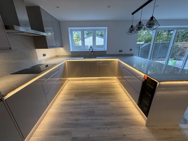 Warm lighting beneath kitchen cabinets and along the plinth